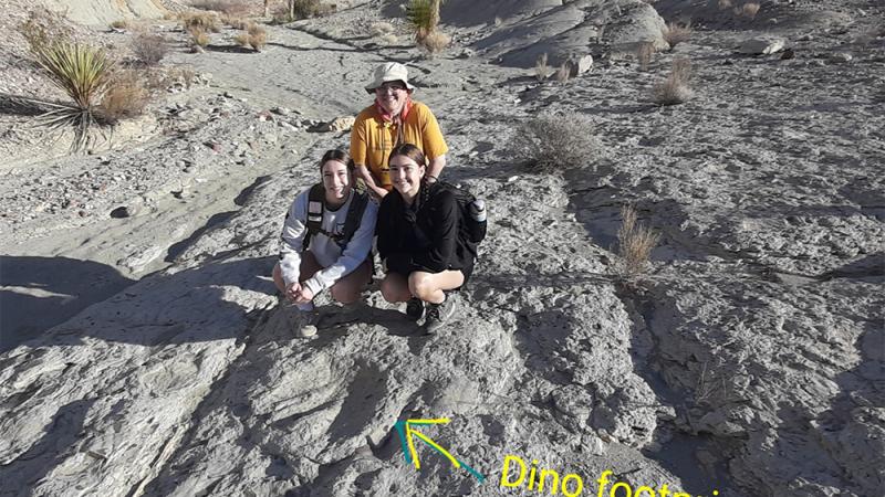 Dr. Amy Berger and Students posing in front of Dinosaur footprint