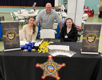 Darian (Left) offering resources at the Seneca County Sheriff's Office's booth at a community event